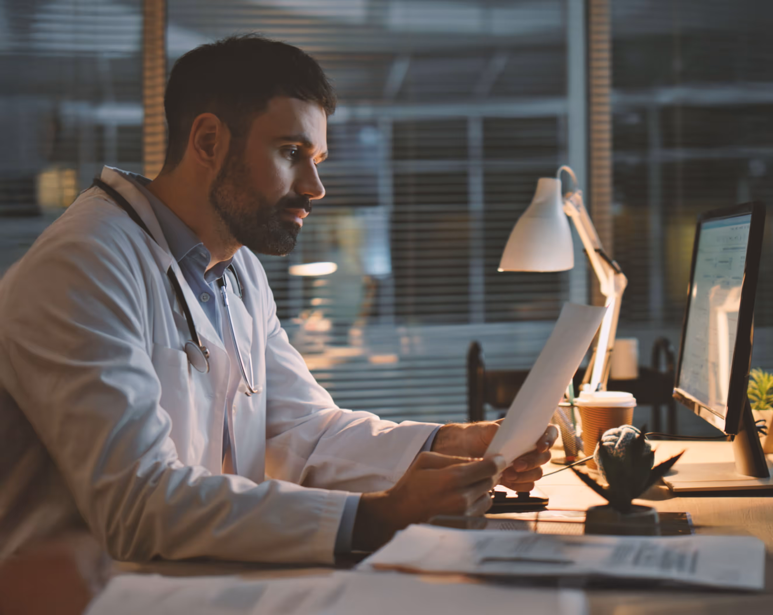 Tired doctor at night looking at chart. 