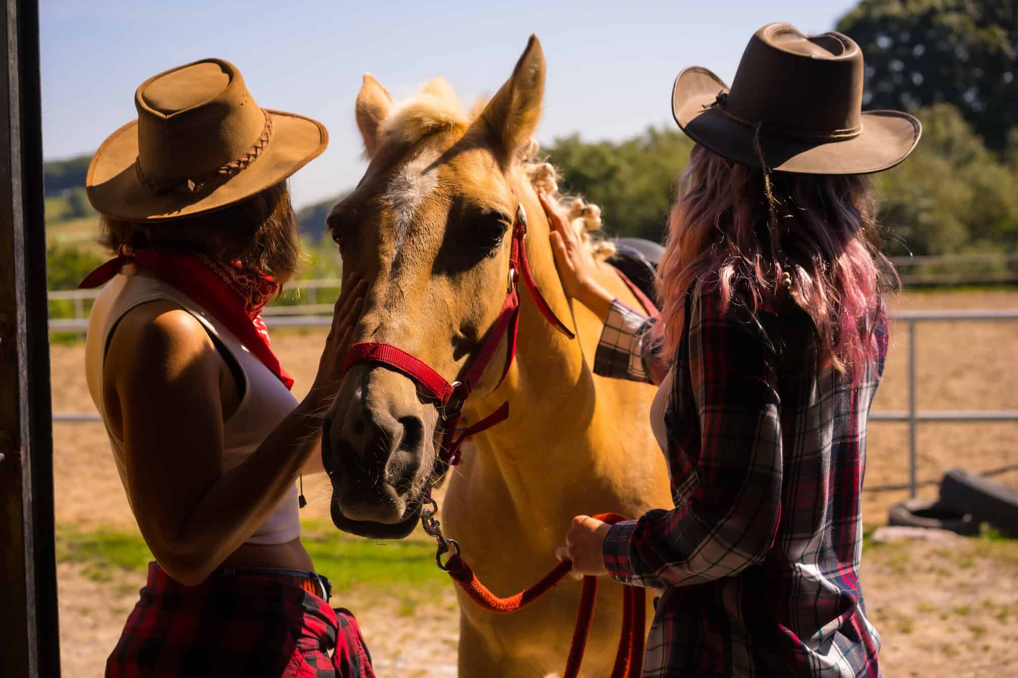 two cowgirls taking care of a horse