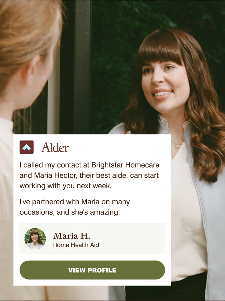 Older adult speaking with smiling caregiver in white jacket; Alder Life Care testimonial from Maria H.
