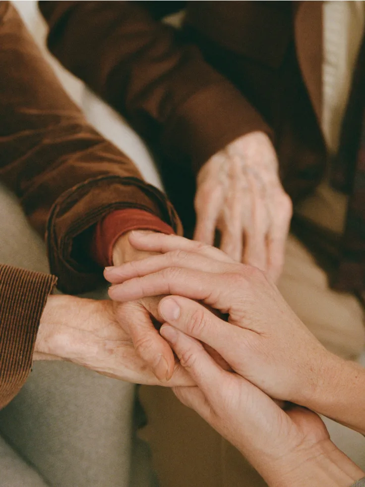 Multiple generations stacking hands together in support and unity.