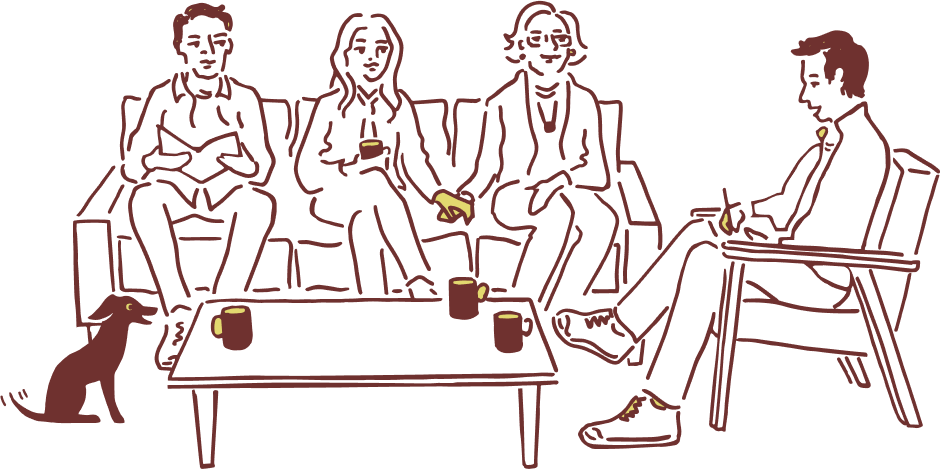 Diverse group of adults sitting together with a dog, discussing over coffee at a table in a care management setting.