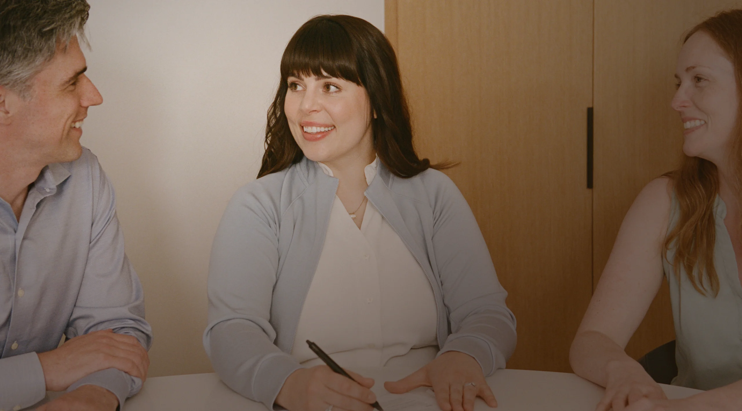 Alder Life Care care manager smiling during consultation with adult family members at table