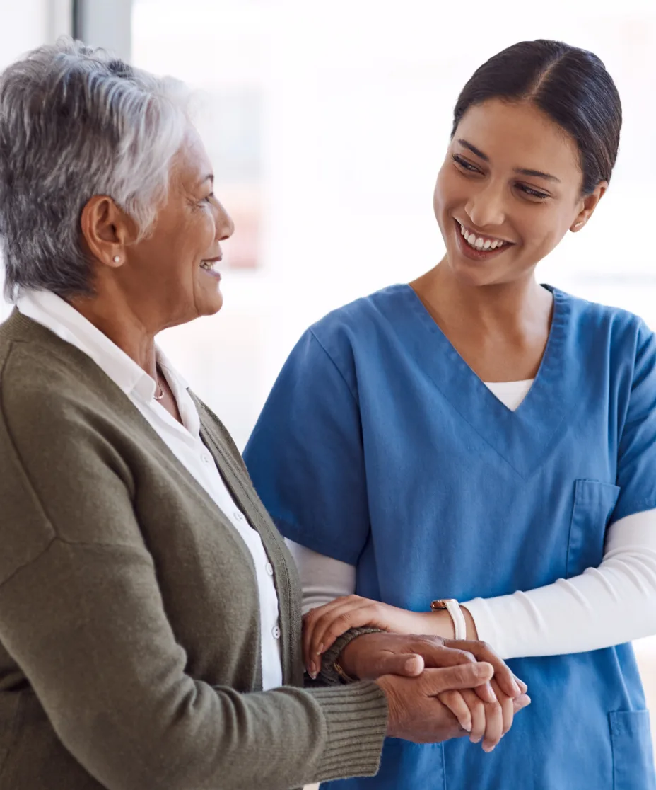 Nurse holding hands with an older patient, providing compassionate elder care support