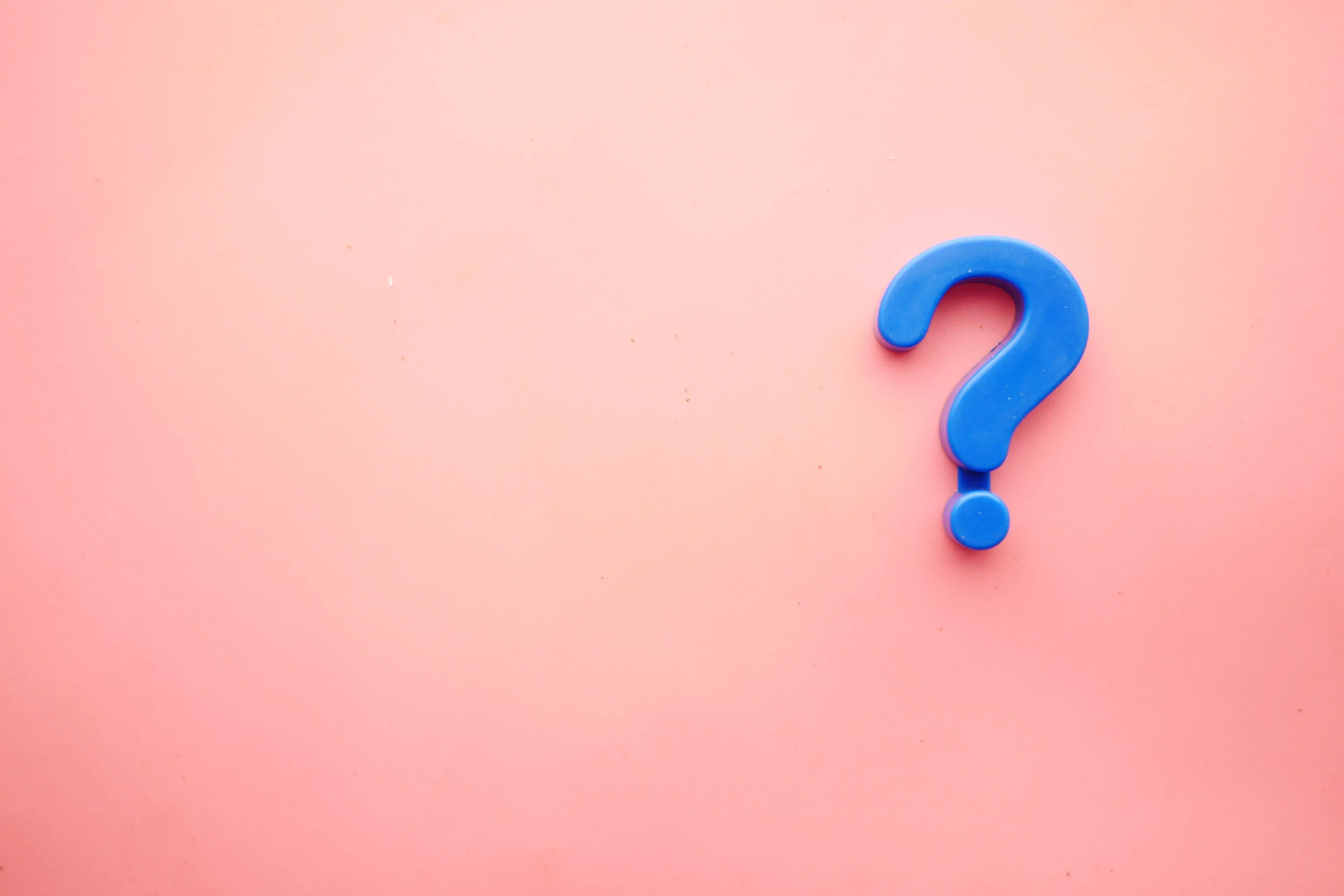A blue question mark on a pink background with space around it.