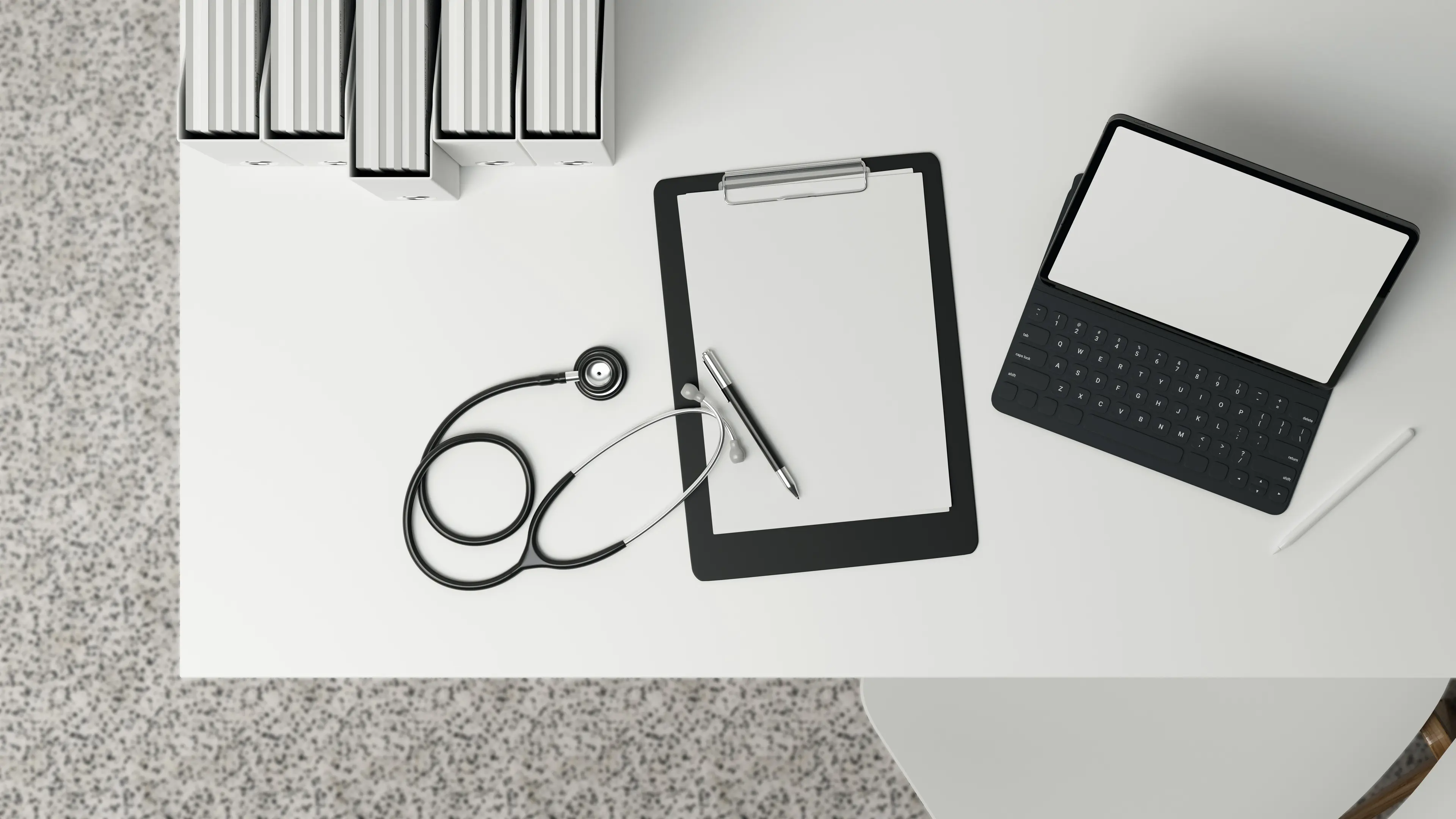Top-down view of a doctor’s desk with a stethoscope, clipboard with blank paper, pen, and a tablet with a keyboard case, alongside stacked binders.
