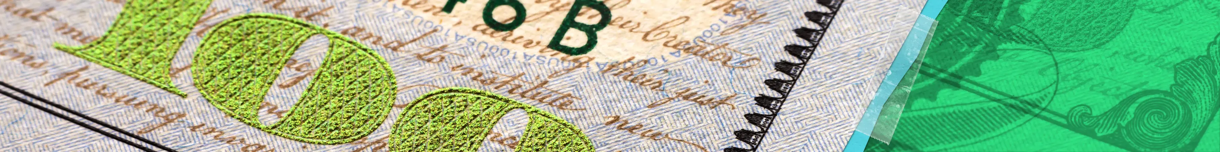 Close-up of the word '100' in green on a U.S. one hundred dollar bill.