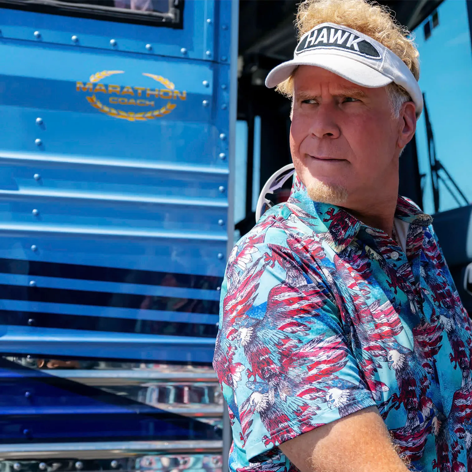 Will Ferrel wearing a HAWK visor and eagle-patterned shirt opening the door of a blue Marathon Coach bus.