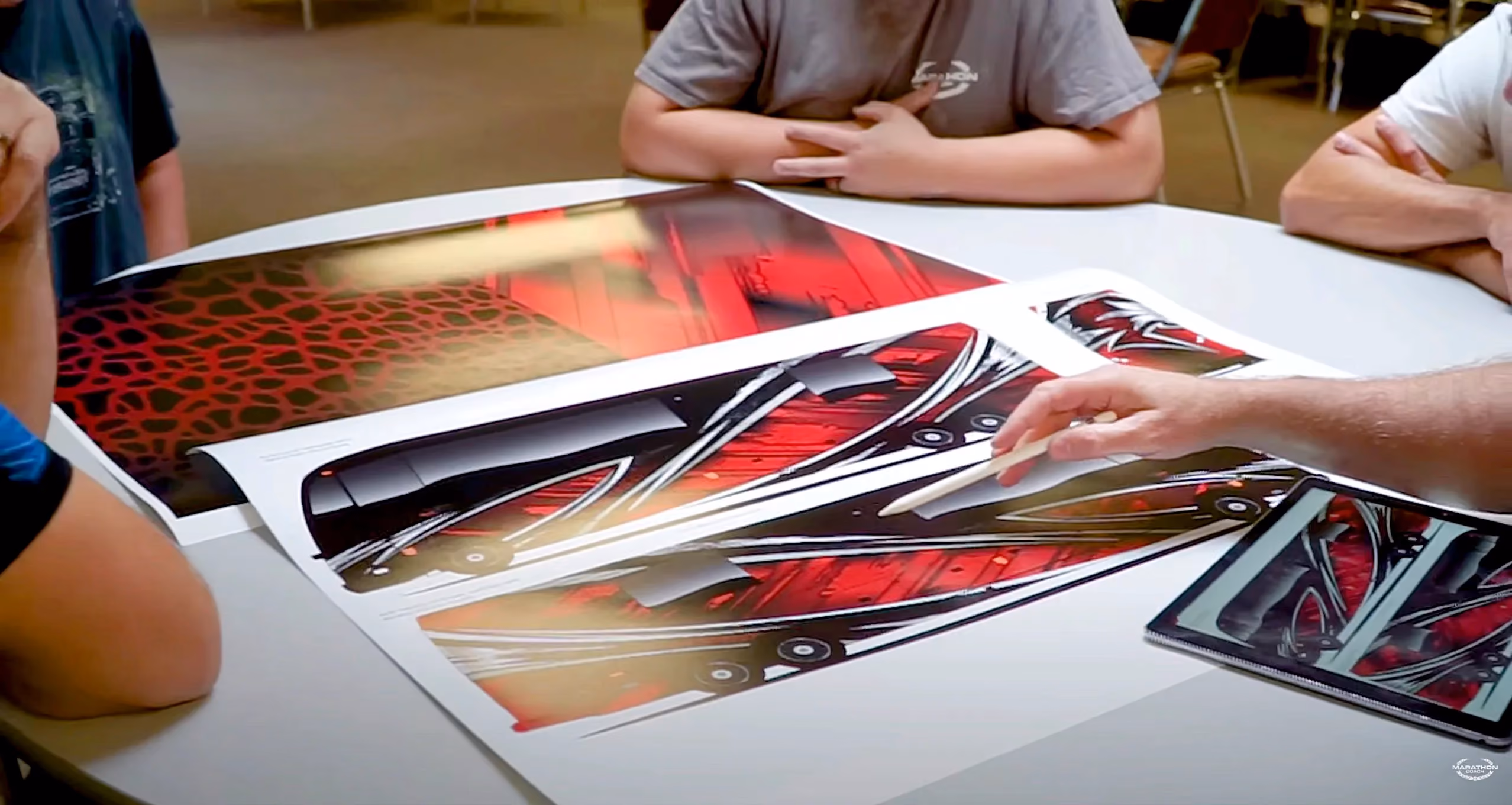 Marathon employees taking a look at custom paint concepts for a coach