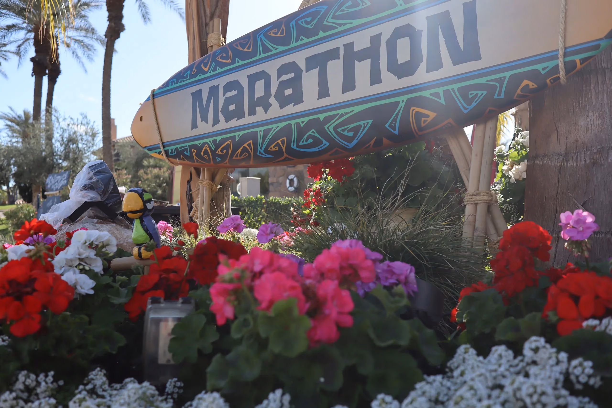 A Marathon Coach surfboard sign at a tiki party
