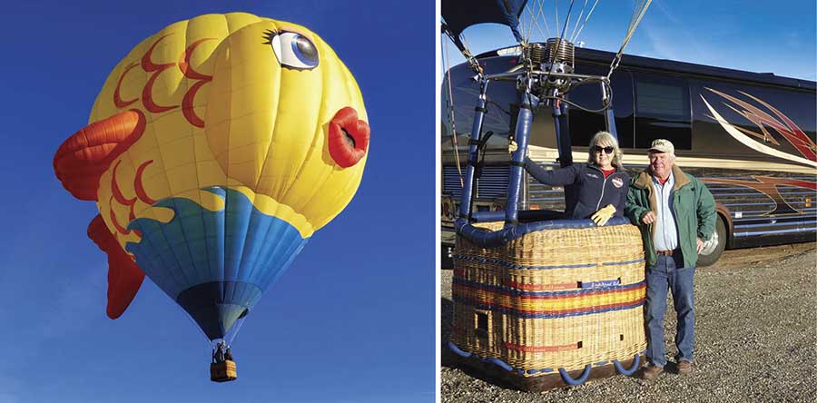 A hot air balloon and 2 people standing with a hot air balloon