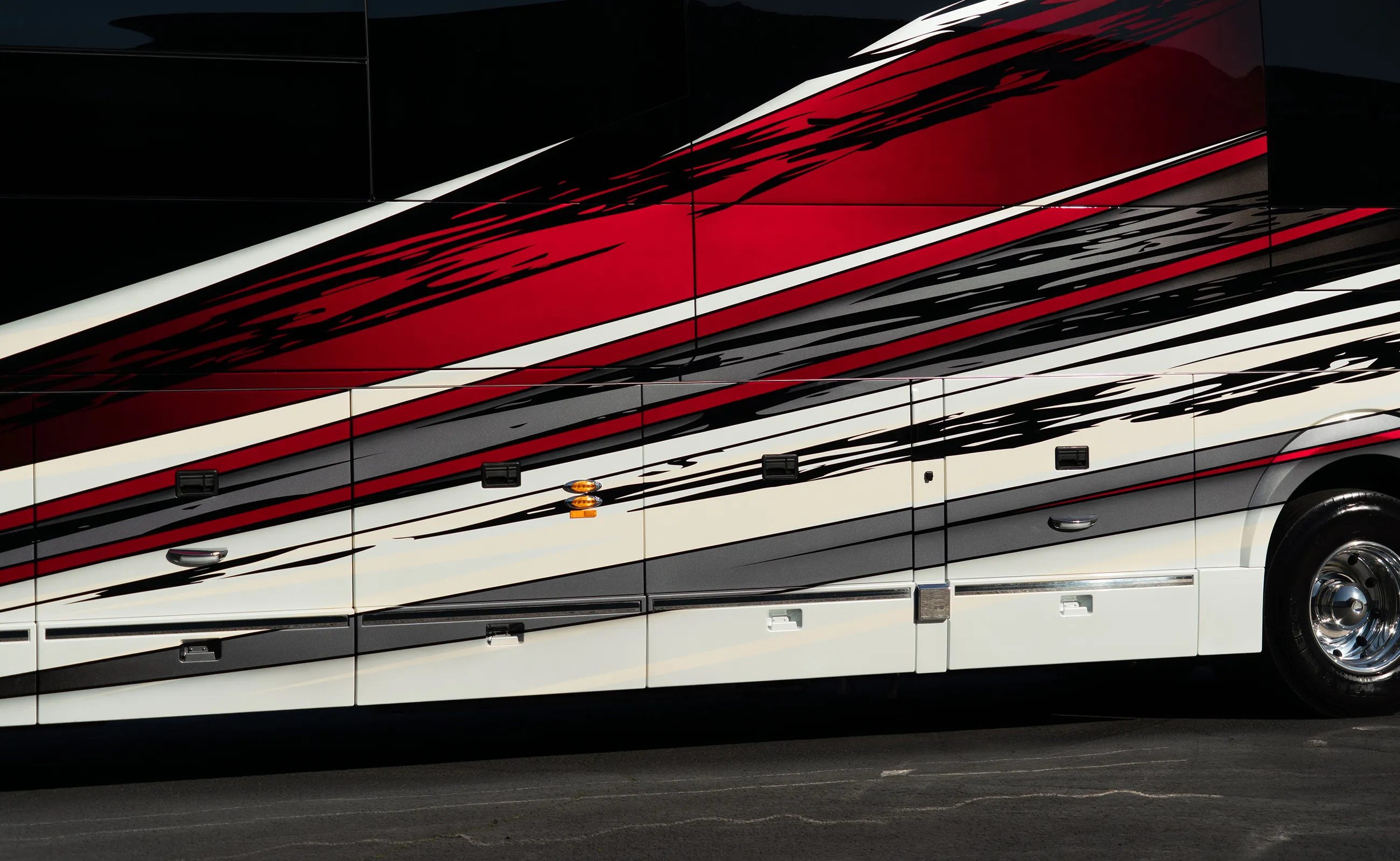 A zoomed in view of the side of MarathonCoach 1419. The paint job is detailed and full of movement. Featuring deep shades of red, black, charcoal, white and cream.