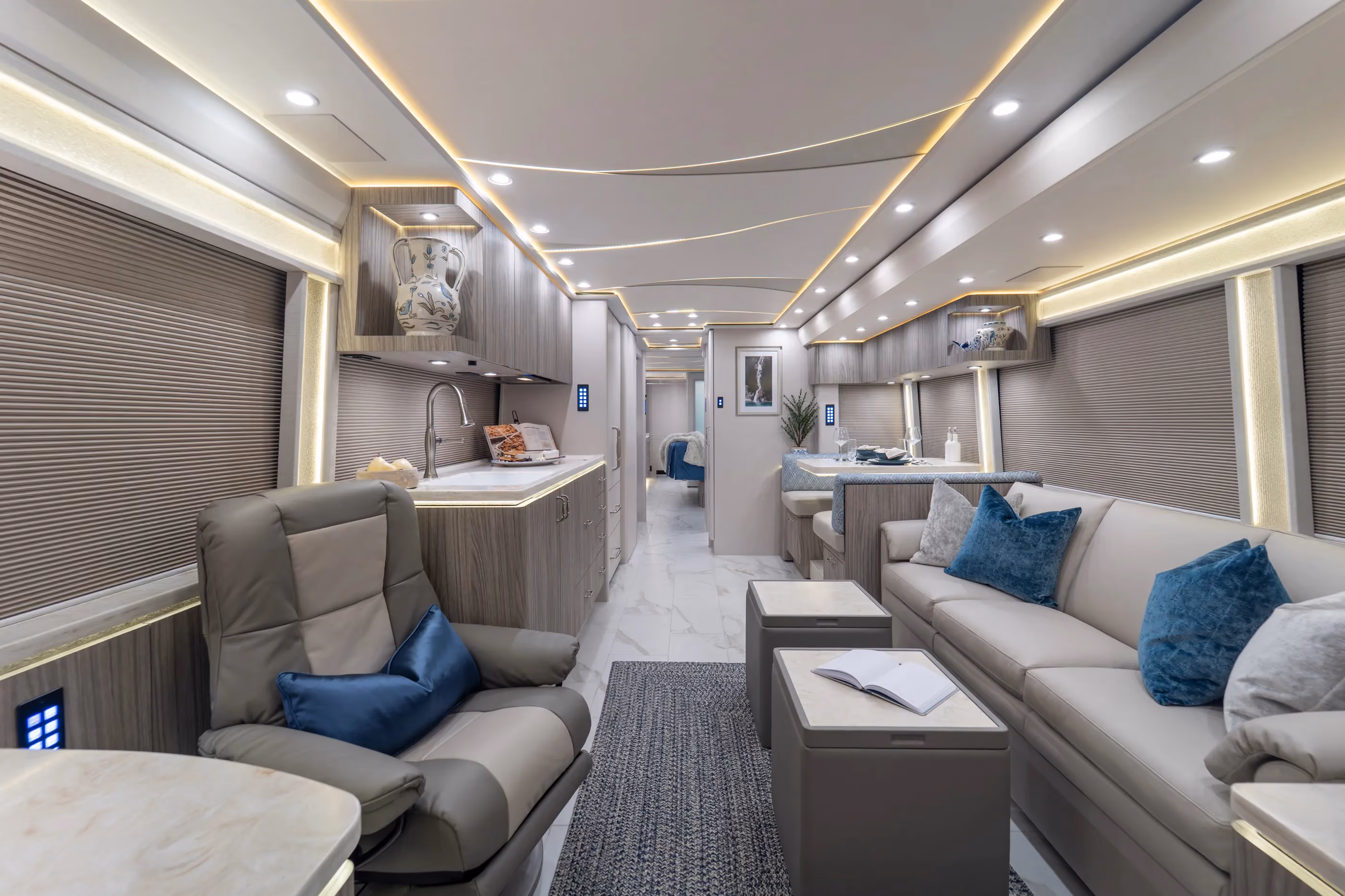 Modern interior of 2027 luxury Marathon Coach #1428 with a grey leather armchair and bench seating