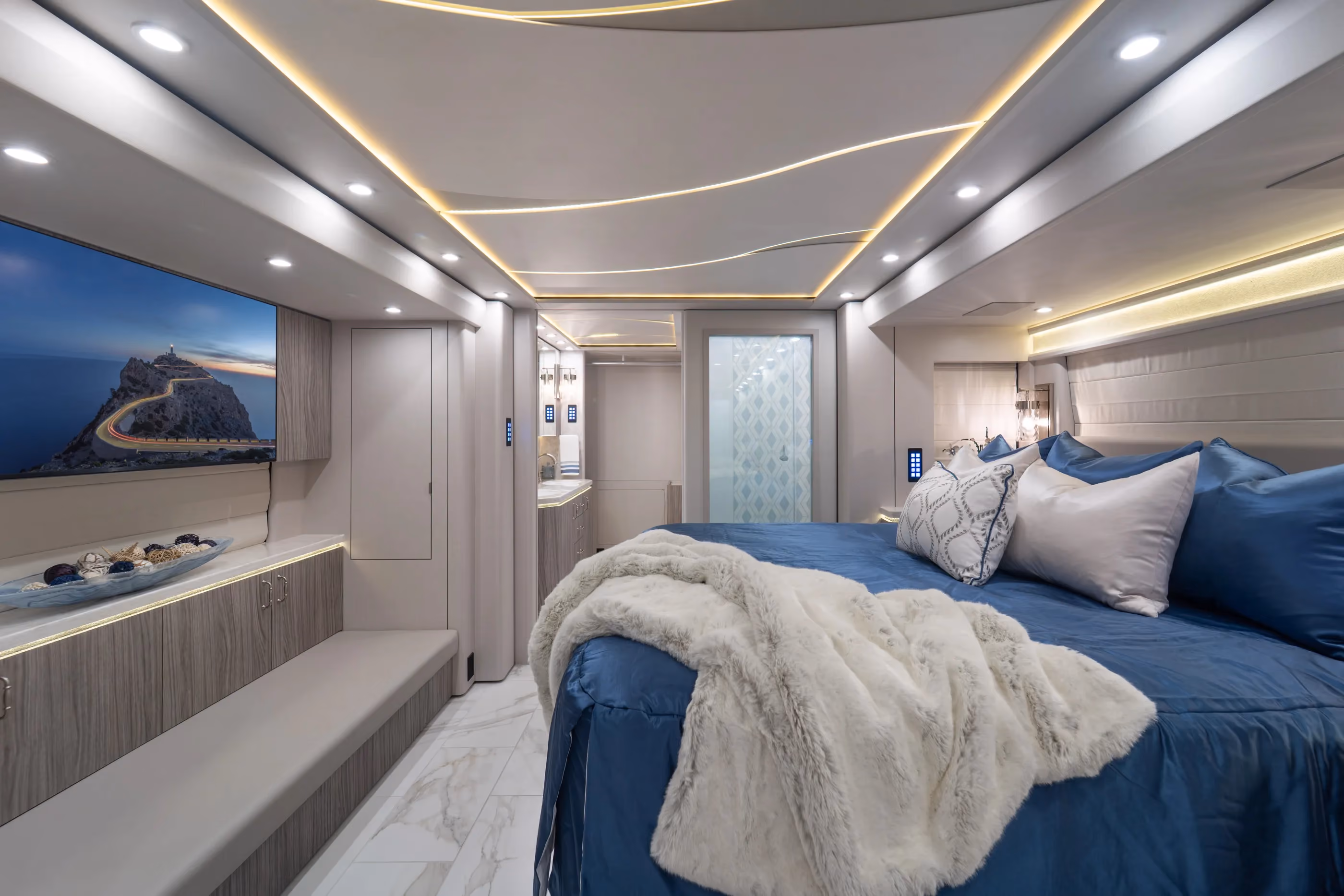 Modern bedroom in Marathon Coach #1428 with custom drawers and a mounted TV