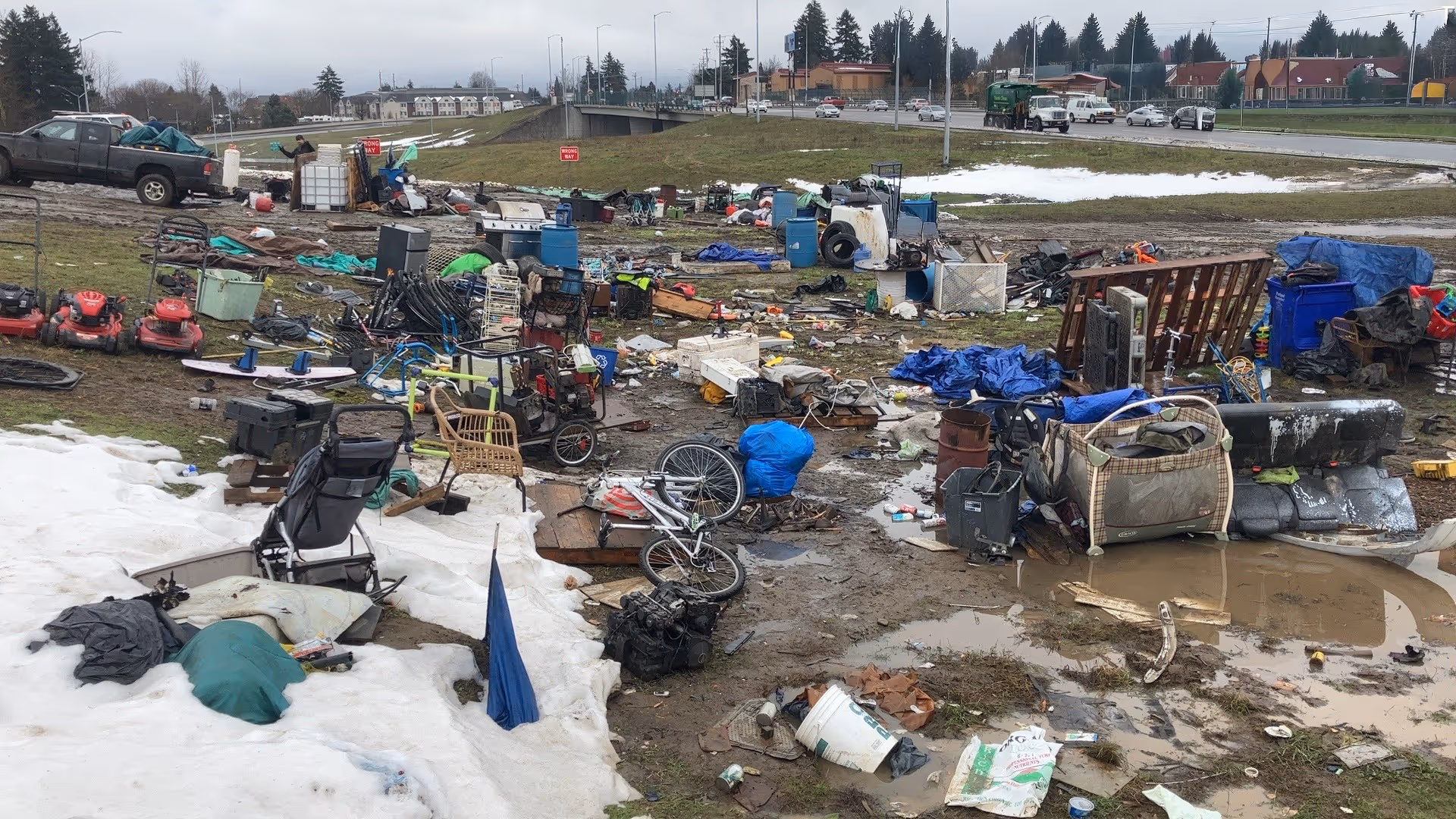 Large outdoor area covered with scattered trash and discarded items 