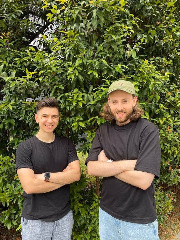 An image of Faba co-founders Alex & Sean standing outside in front of a blossoming tree