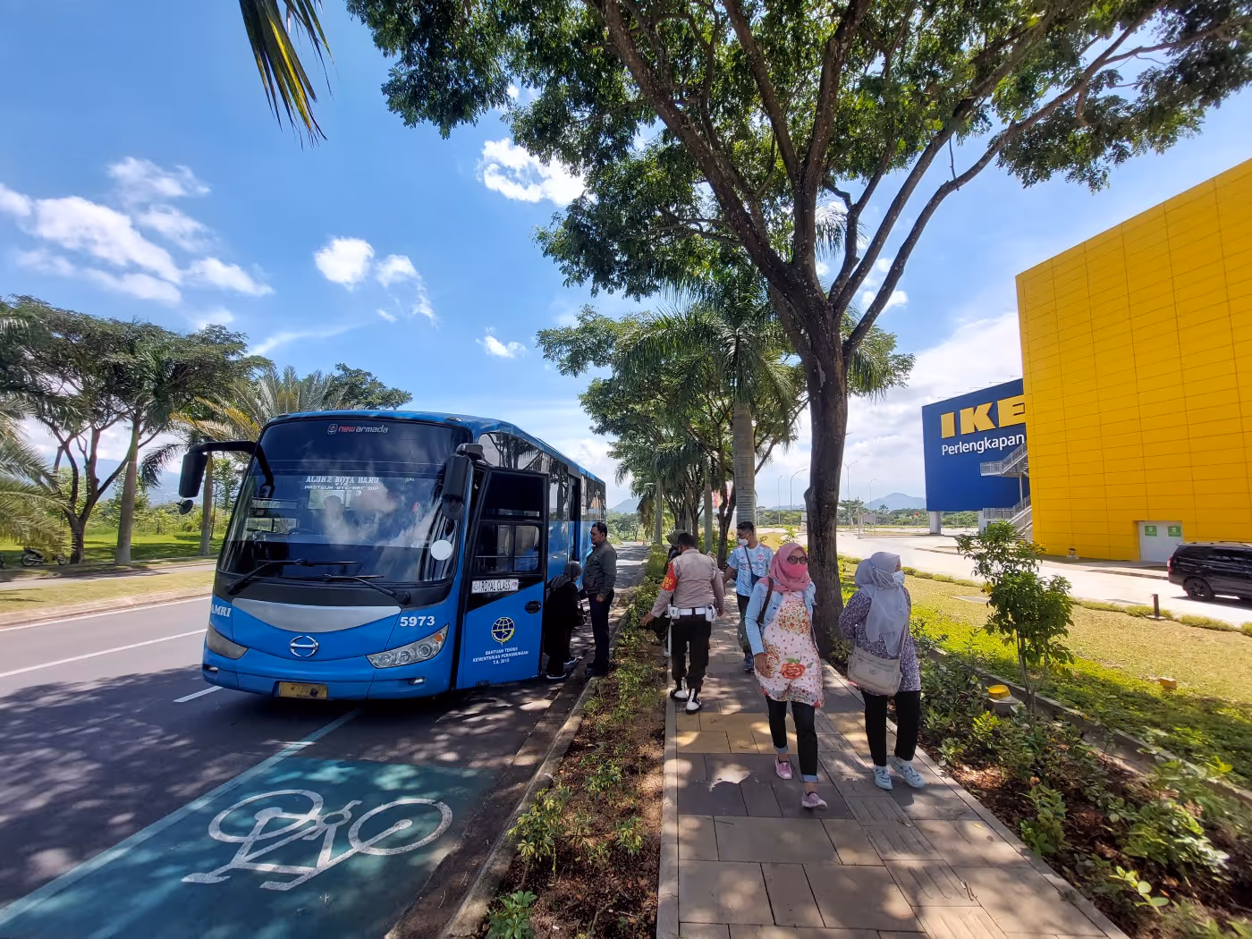 Blue bus parked on the side of the road as passengers disembark outside ikea 