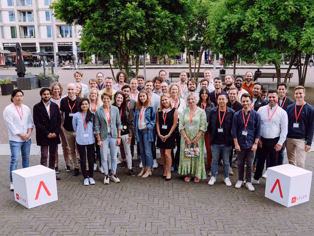 Group wearing lanyards take a photo with Antler logo cubes in Amsterdam 
