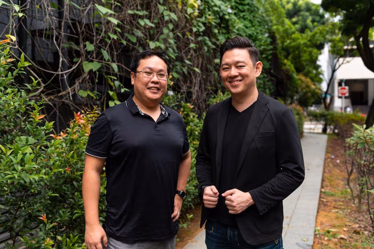 YourRent CTO Joshua Sim Ming Wei and CEO Daryl Lim posing together outside with greenery in the background 