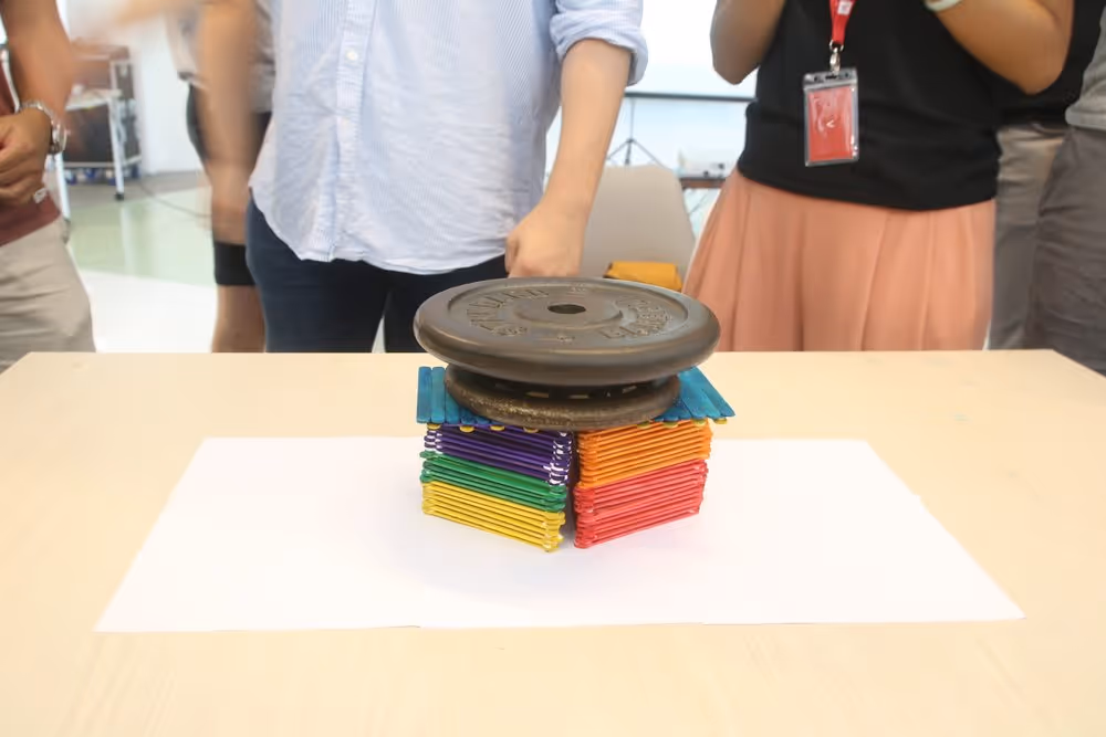 An image of a group's finished ice block stick structure supporting a weighted plate