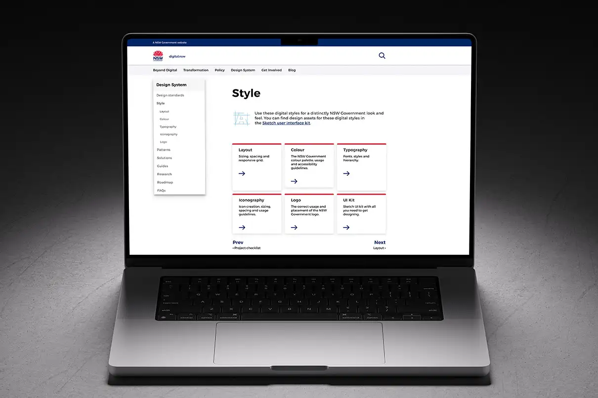 Design System Style page on a laptop, outlining layout, colour, typography, and iconography guidance.
