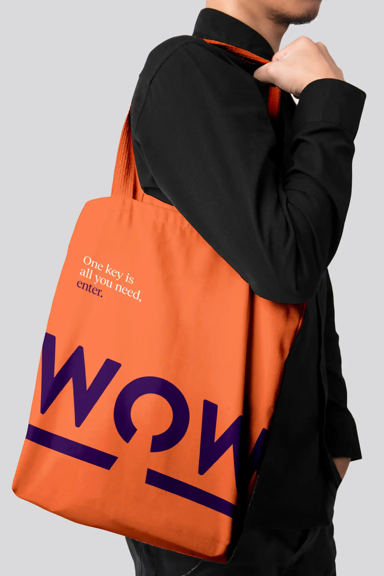 Person carrying an orange tote bag with the Trove campaign word ‘WOW’ printed in large purple type and the tagline ‘One key is all you need, enter.’