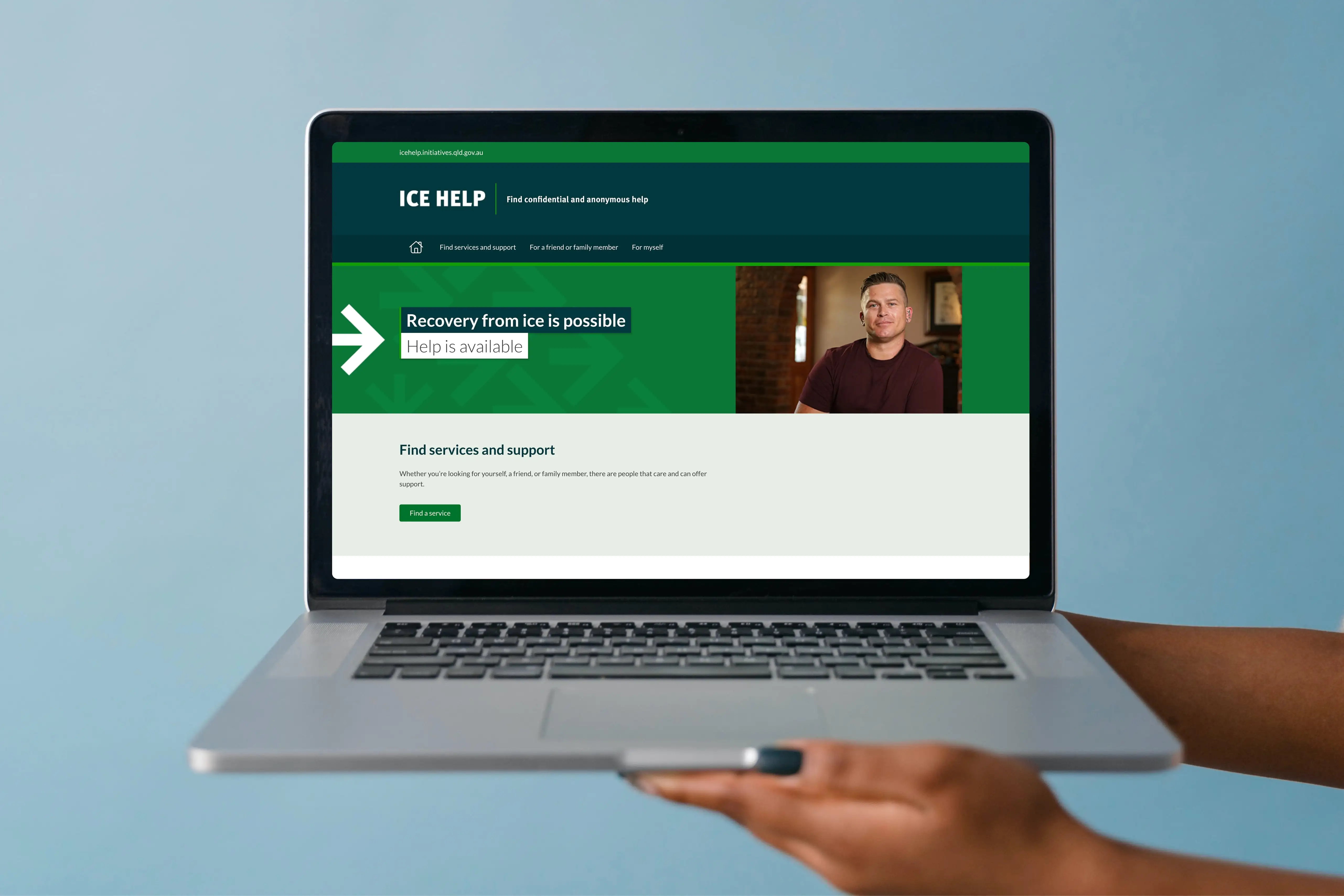 A person holding a laptop displaying the redesigned ICE Help website, highlighting support pathways.