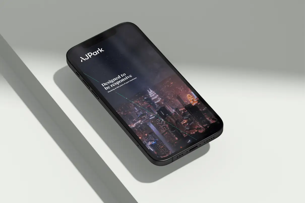 Smartphone displaying the AJ Park website homepage with a night-time cityscape and the message ‘Designed to be responsive.’