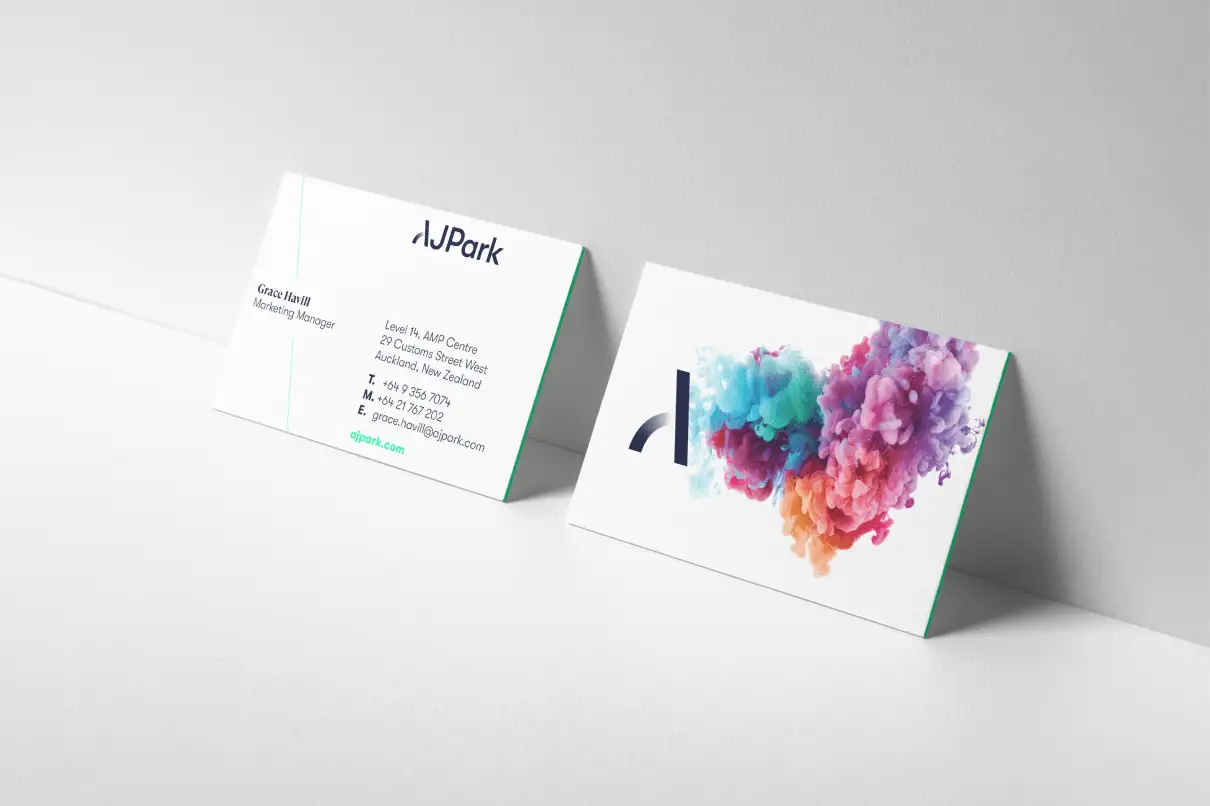 Front and back of AJ Park business cards, one showing brand mark and colourful ink motif, the other showing contact details for a marketing manager.