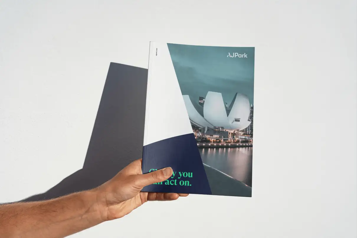 Front and back of AJ Park business cards, one showing brand mark and colourful ink motif, the other showing contact details for a marketing manager.