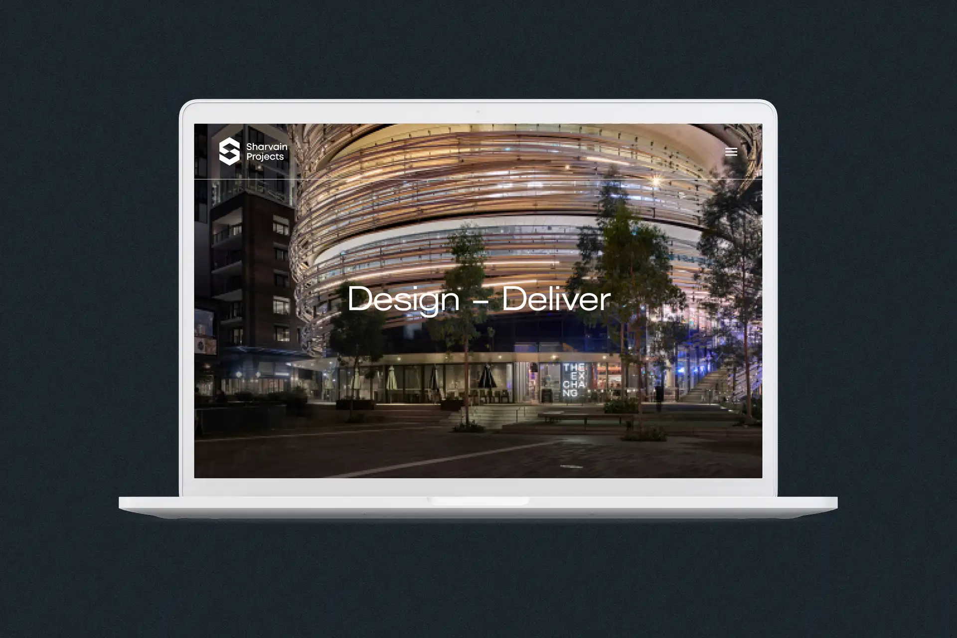 Sharvain Projects homepage displayed on a laptop, featuring a nighttime architectural facade and the headline “Design — Deliver.”