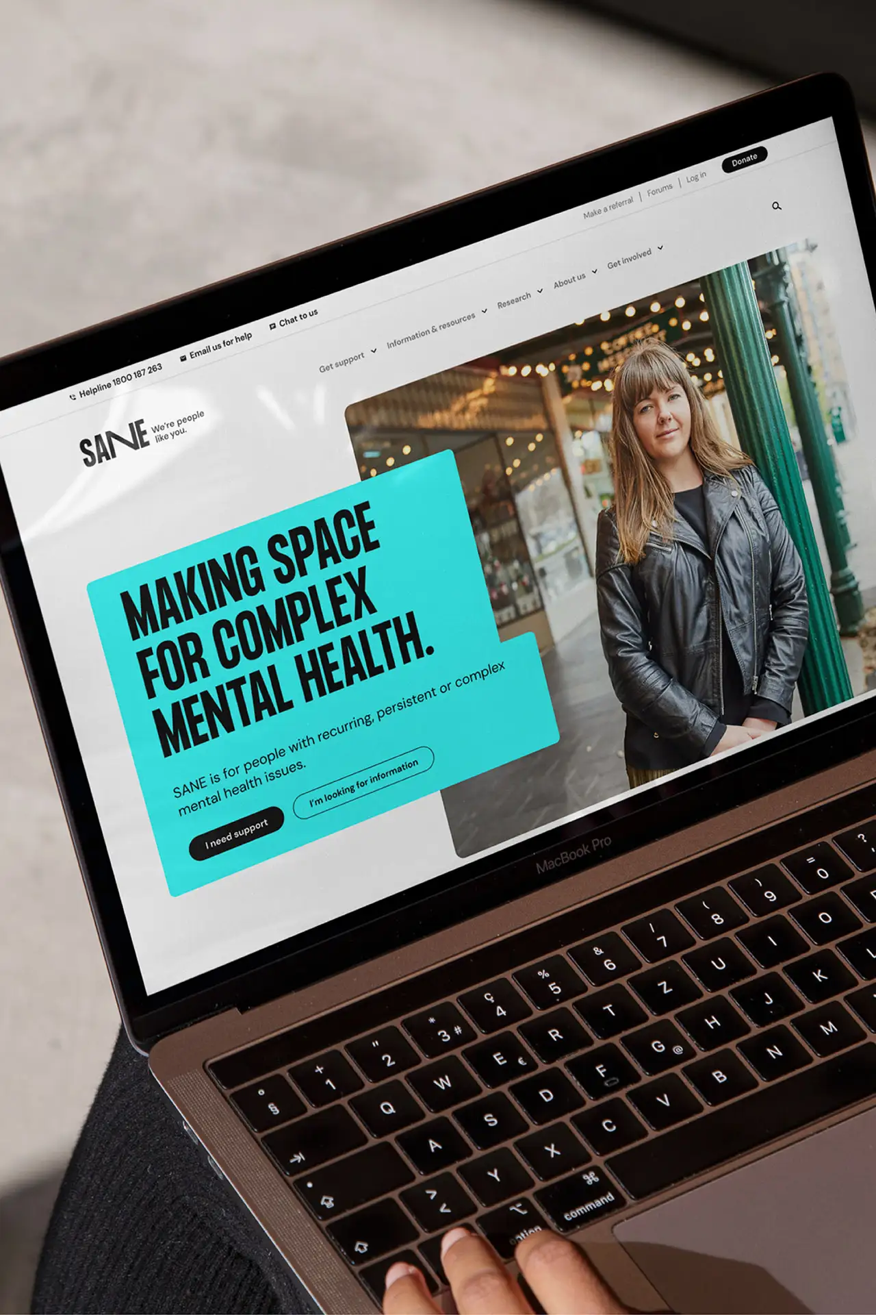 Laptop showing the SANE homepage and a Good Design Award Gold Winner badge sits below.