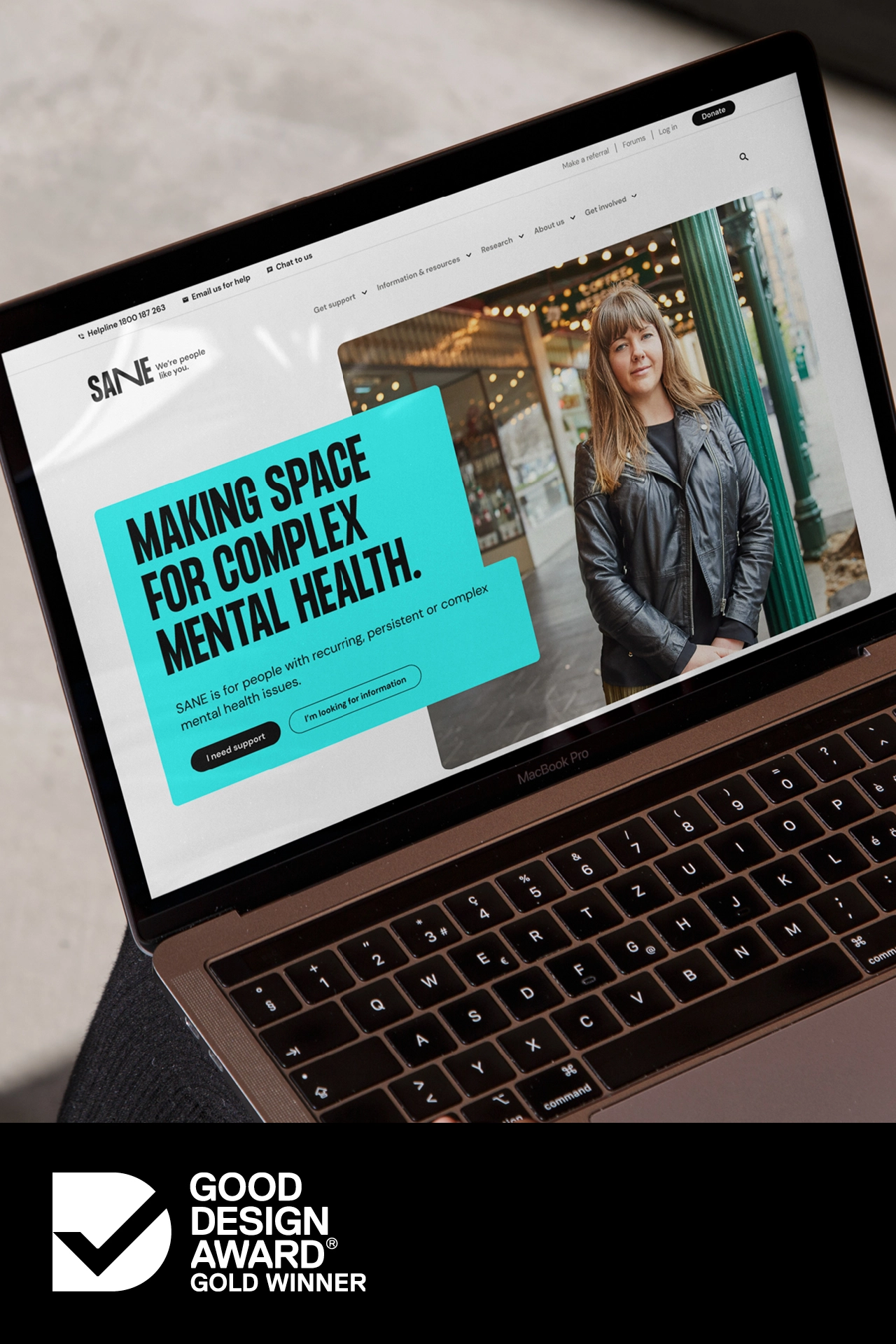 Laptop showing the SANE homepage and a Good Design Award Gold Winner badge sits below.