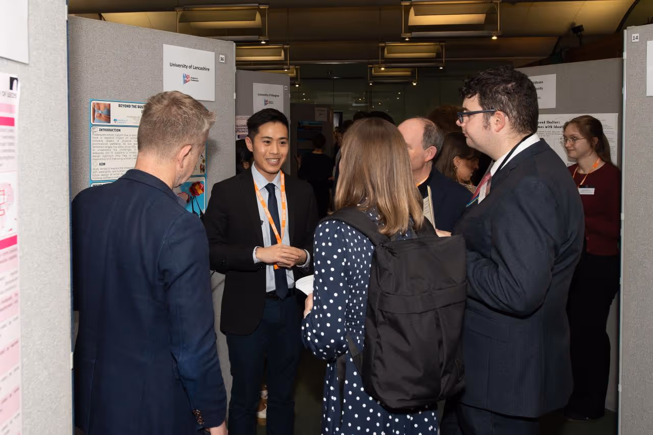 Judges of the Research Communication Competition speaking to shortlisted candidate Yik Nok Bryan Lee, University of Lancashire