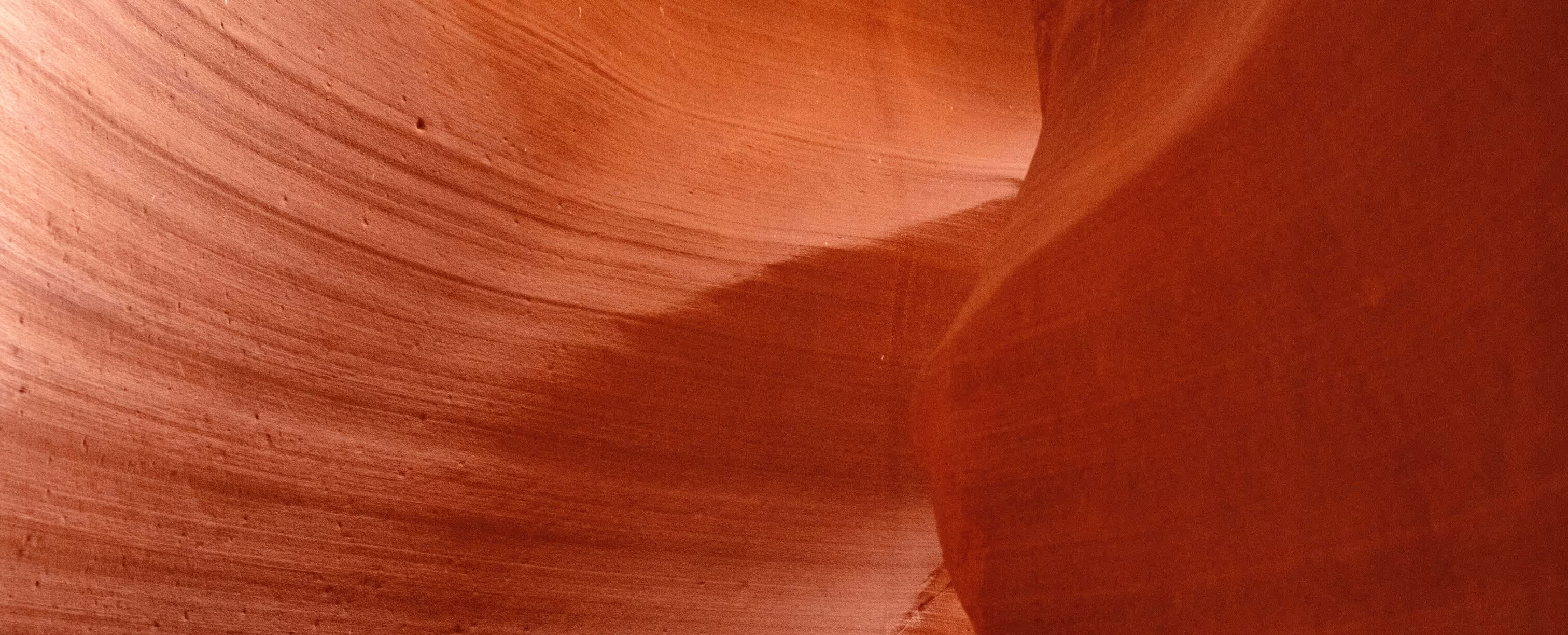 Smooth, curved red sandstone walls inside a narrow canyon with layered textures.