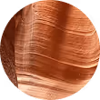 Close-up of a smooth, round sandstone rock with layered textures in warm brown tones.