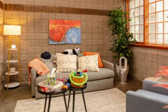 A ketamine-assisted psychotherapy session room in Scottsdale, with a sofa, cushions, blankets and warm lamp lighting rather than a clinical setting
