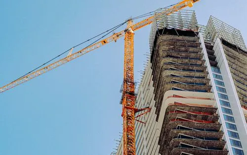 Construction crane next to a high-rise building 