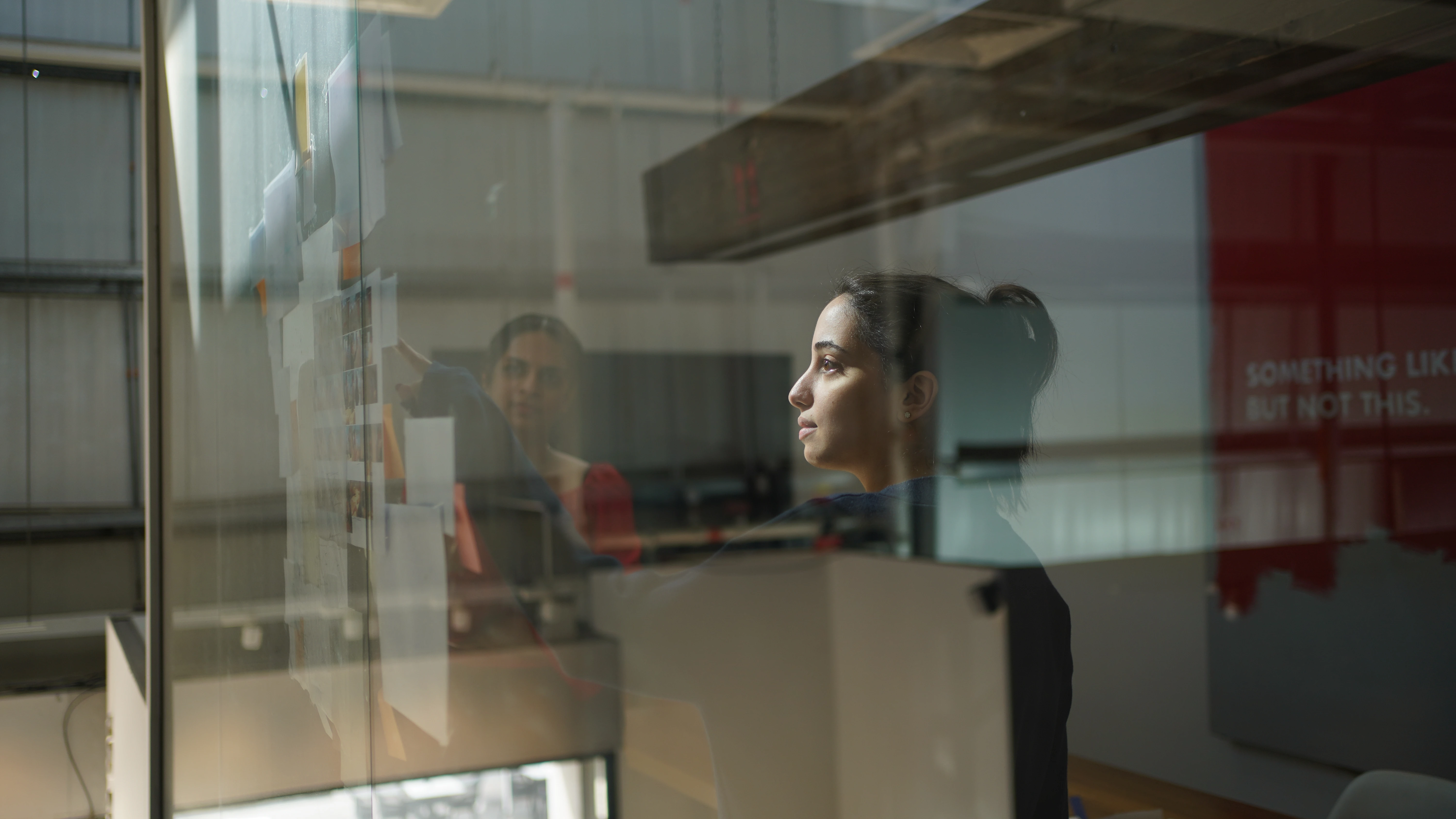 Close up of a LIMAH designer strategizing behind a glass wall