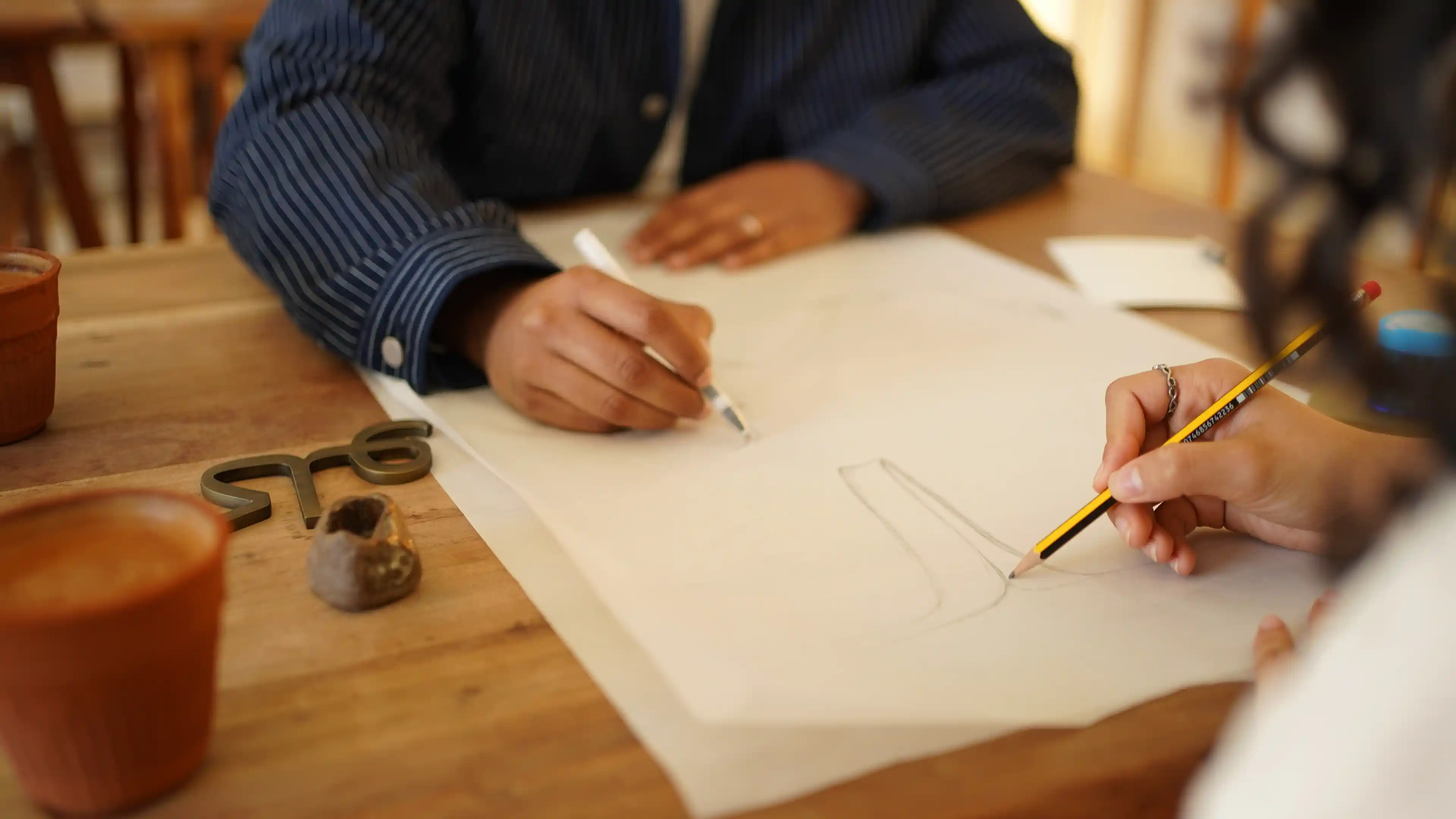 Two LIMAH designers discussing public art sketches over a table