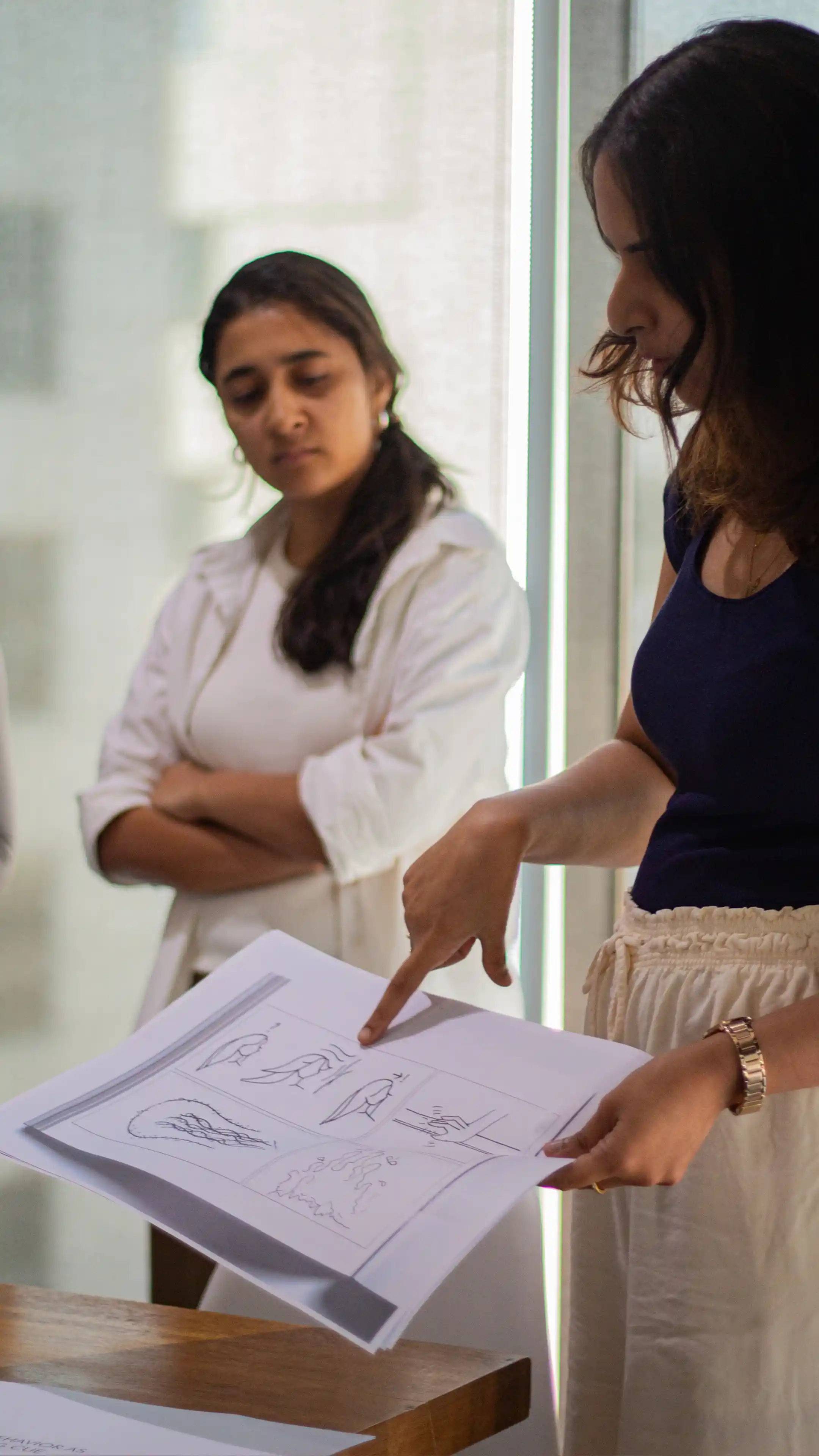 Two LIMAH designers presenting a design concept through sketches to the team