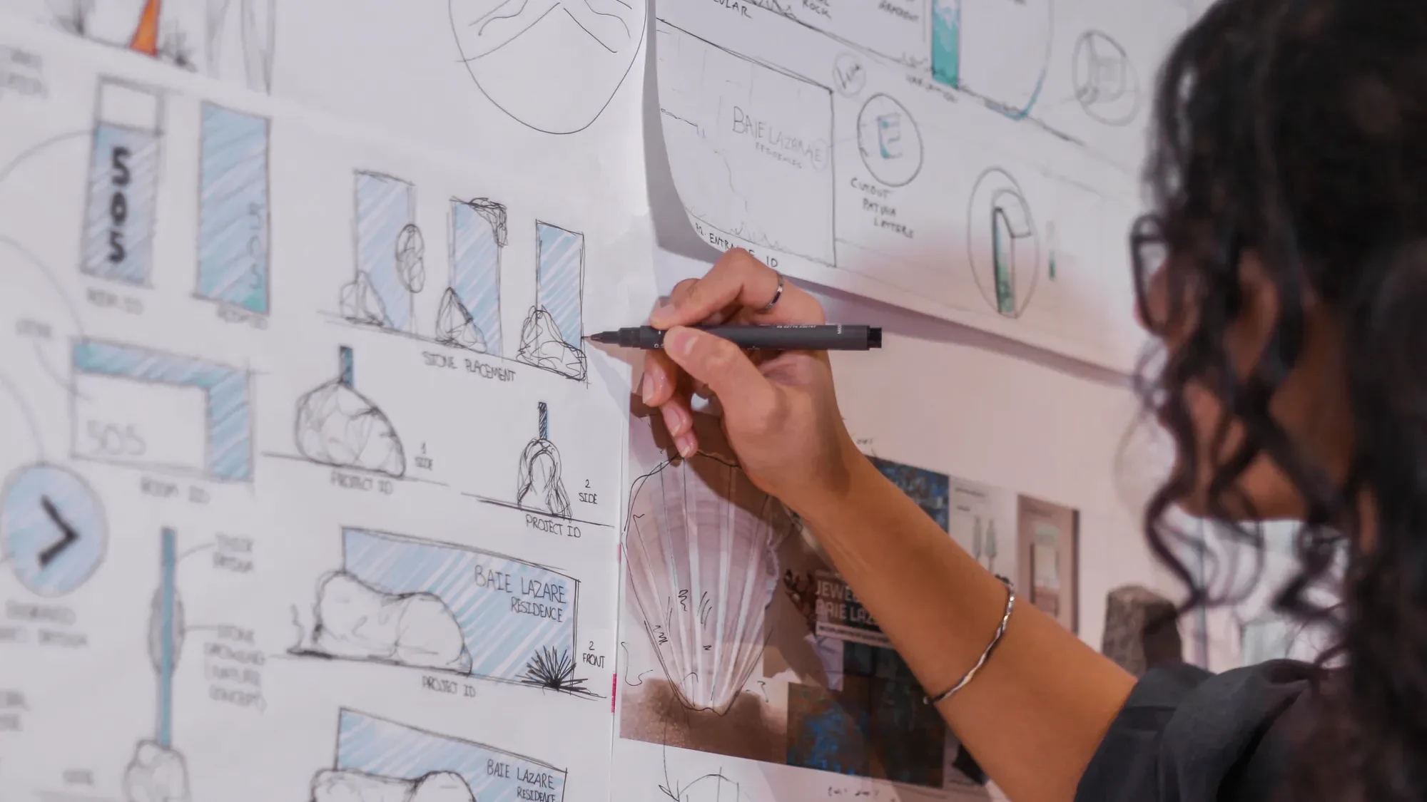 Close-up of a LIMAH designer reviewing early wayfinding and experiential design strategies