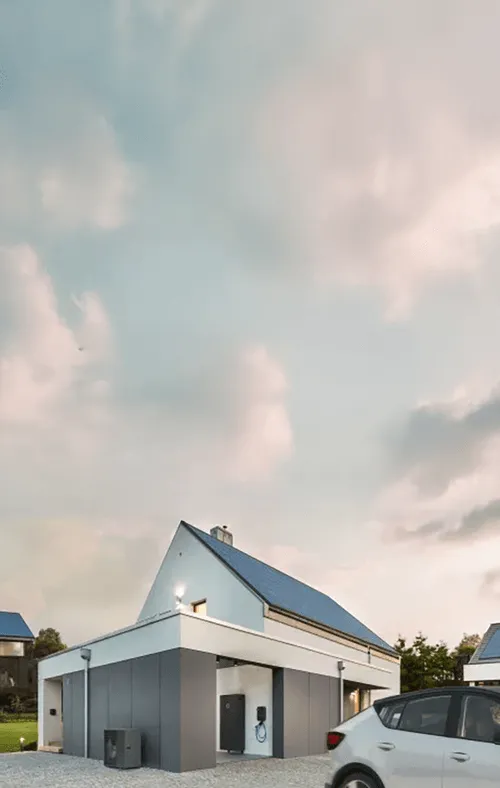 Modernes Einfamilienhaus mit Solaranlage auf dem Dach, sichtbar ist ein sonnenCharger, eine sonnenBatterie sowie ein Elektroauto in der Einfahrt.