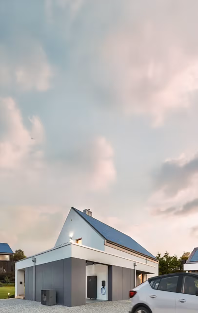 Modernes Einfamilienhaus mit Solaranlage auf dem Dach, sichtbar ist ein sonnenCharger, eine sonnenBatterie sowie ein Elektroauto in der Einfahrt.