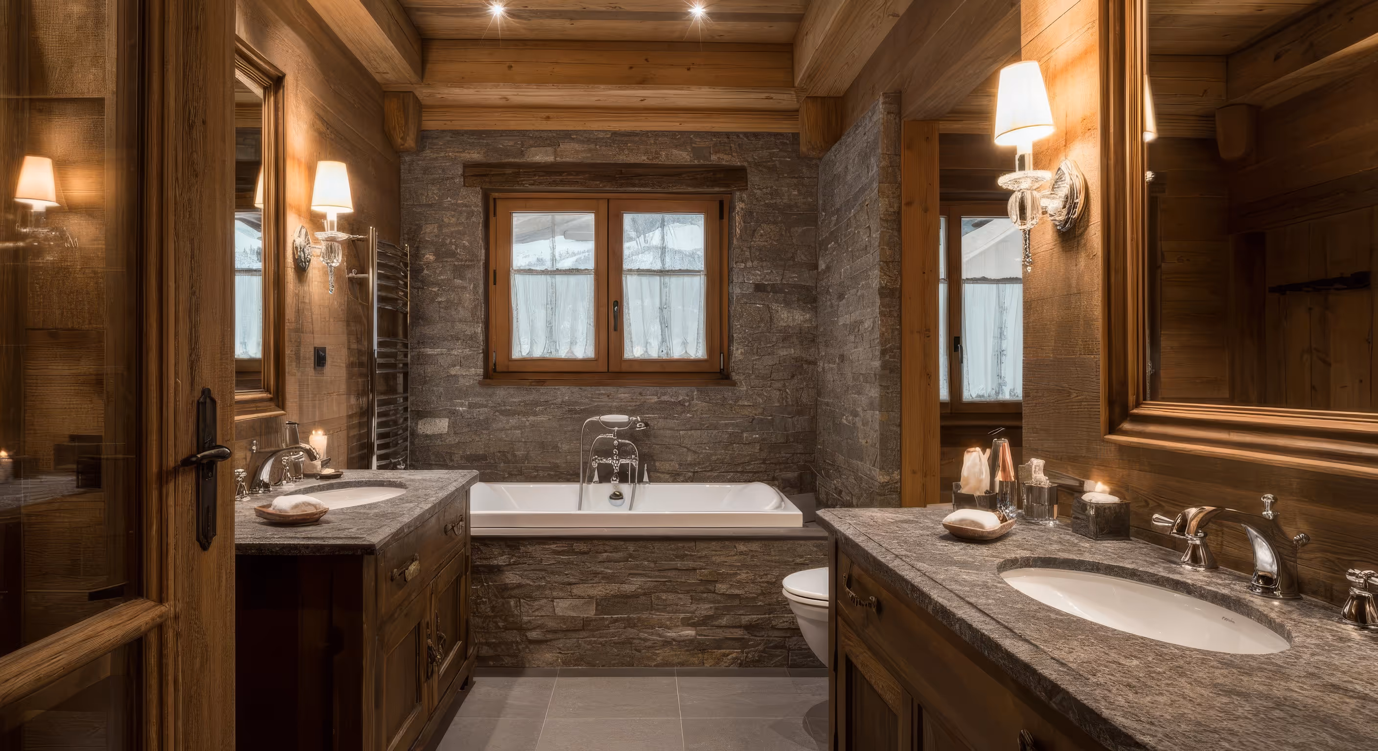 Rustic bathroom with wooden accents, stone walls, a bathtub under a window, and double granite sinks with mirrors and wall lamps.