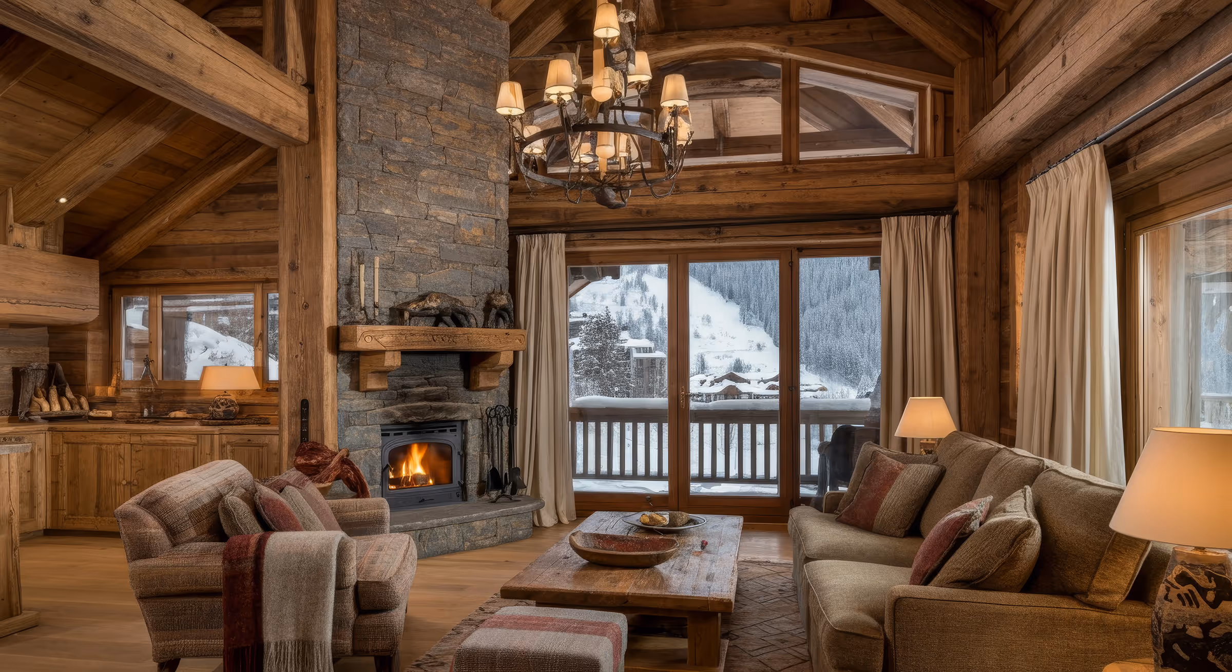 Cozy wooden cabin living room with a stone fireplace, comfortable seating, and a snowy mountain view through large windows.
