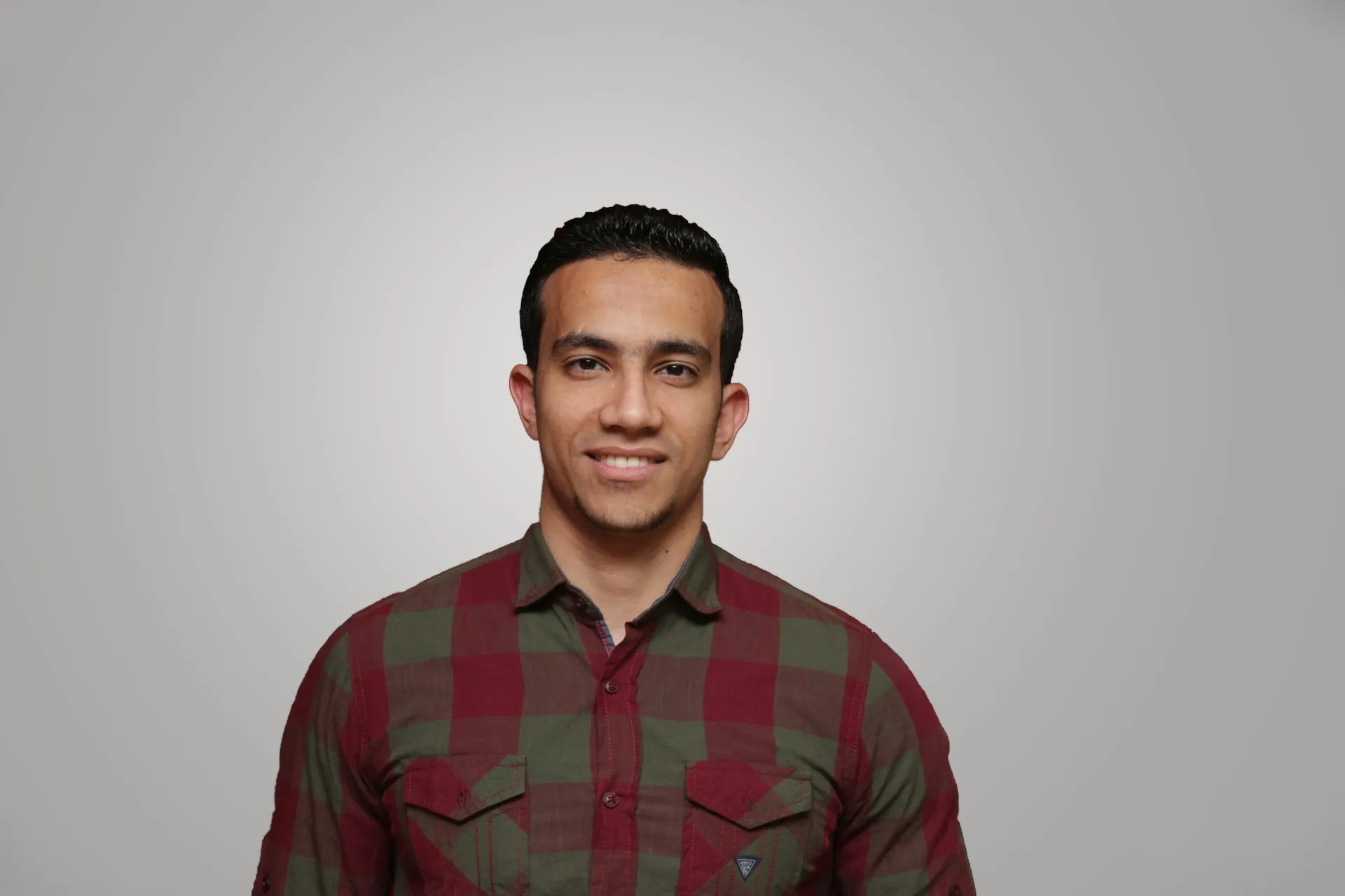 A man wearing a red and green plaid shirt.