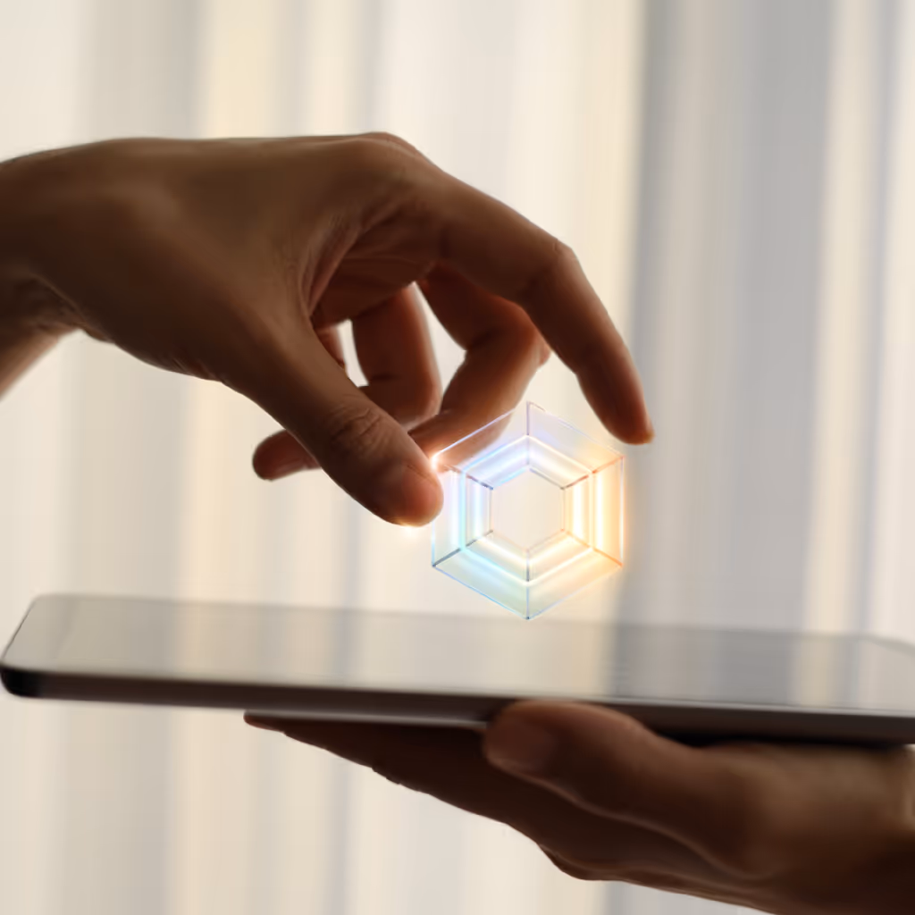 Hand holding a tablet with a glowing holographic hexagonal shape floating above it.