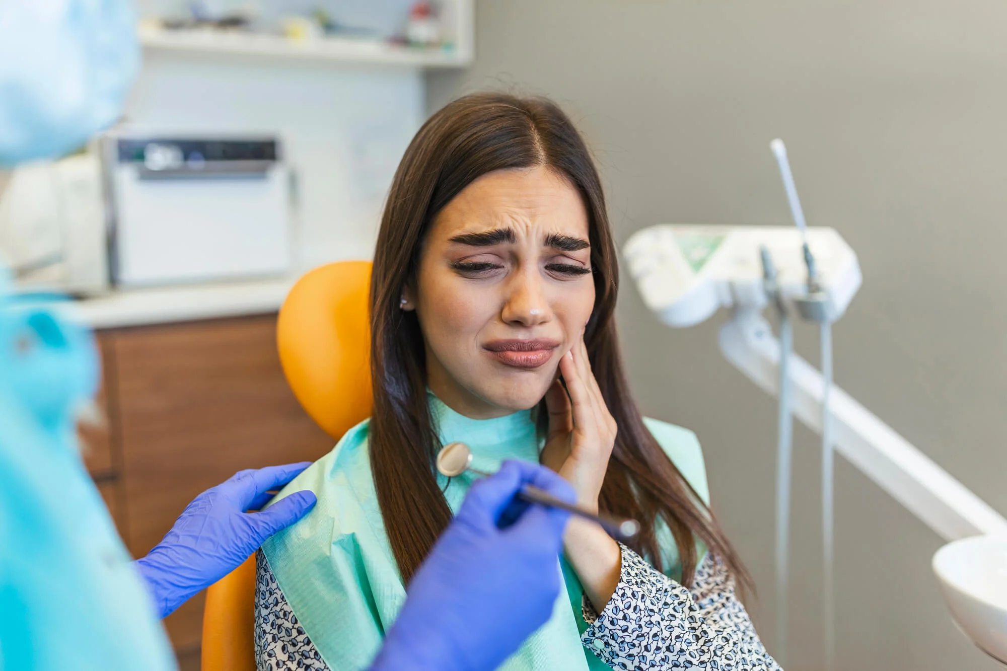 Patient holding cheek with pain visiting an affordable dentist in Easton, PA.