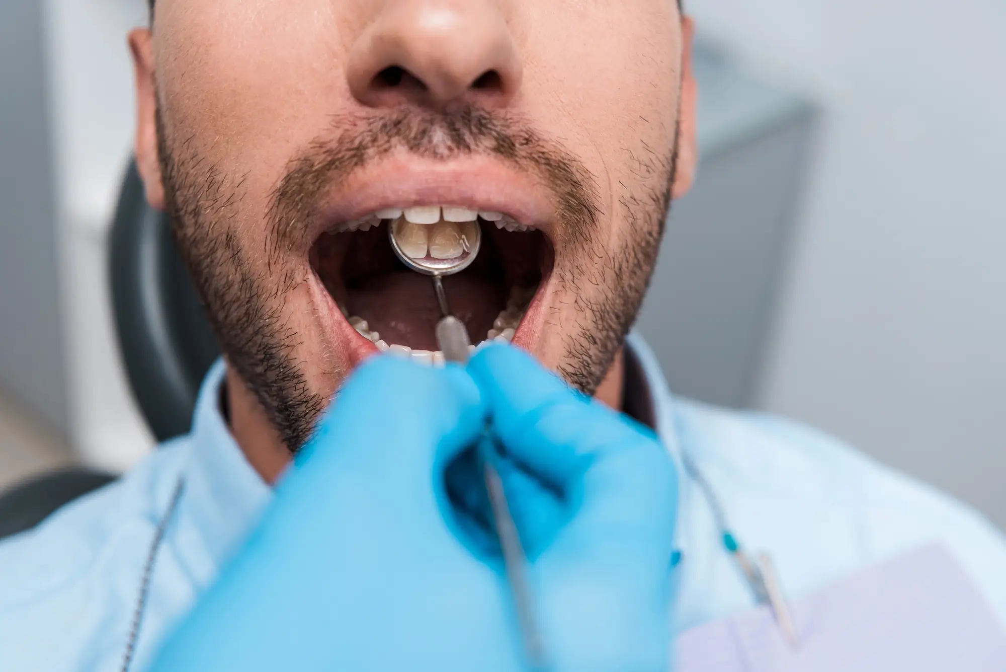 Oral Surgeon in Easton, PA examining a man's open mouth