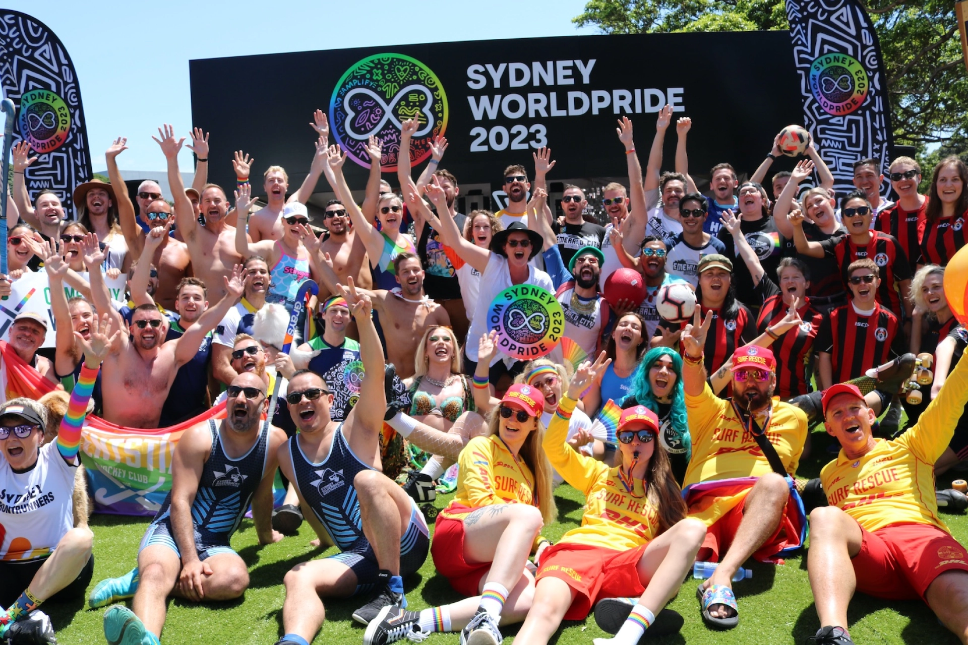 Large crowd marching with rainbow flags and banners during Sydney WorldPride, celebrating LGBTQ+ pride and solidarity.